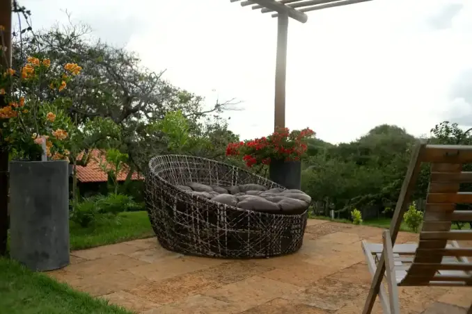 Lounge externo do mirante com chaise e flores vermelhas